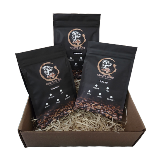 Cruizer Koffie gift box featuring three 250g single origin coffee bags from Colombia, Brazil, and Ethiopia packed in wood wool. Coffee gift box for coffee lovers.