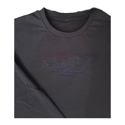 Close-up shot of the high-quality, tone-on-tone dark blue embroidery on a navy sweatshirt, showcasing the detailed satin stitching of six flying birds and the scripture "Look at the birds Matthew 6:26" in elegant cursive.