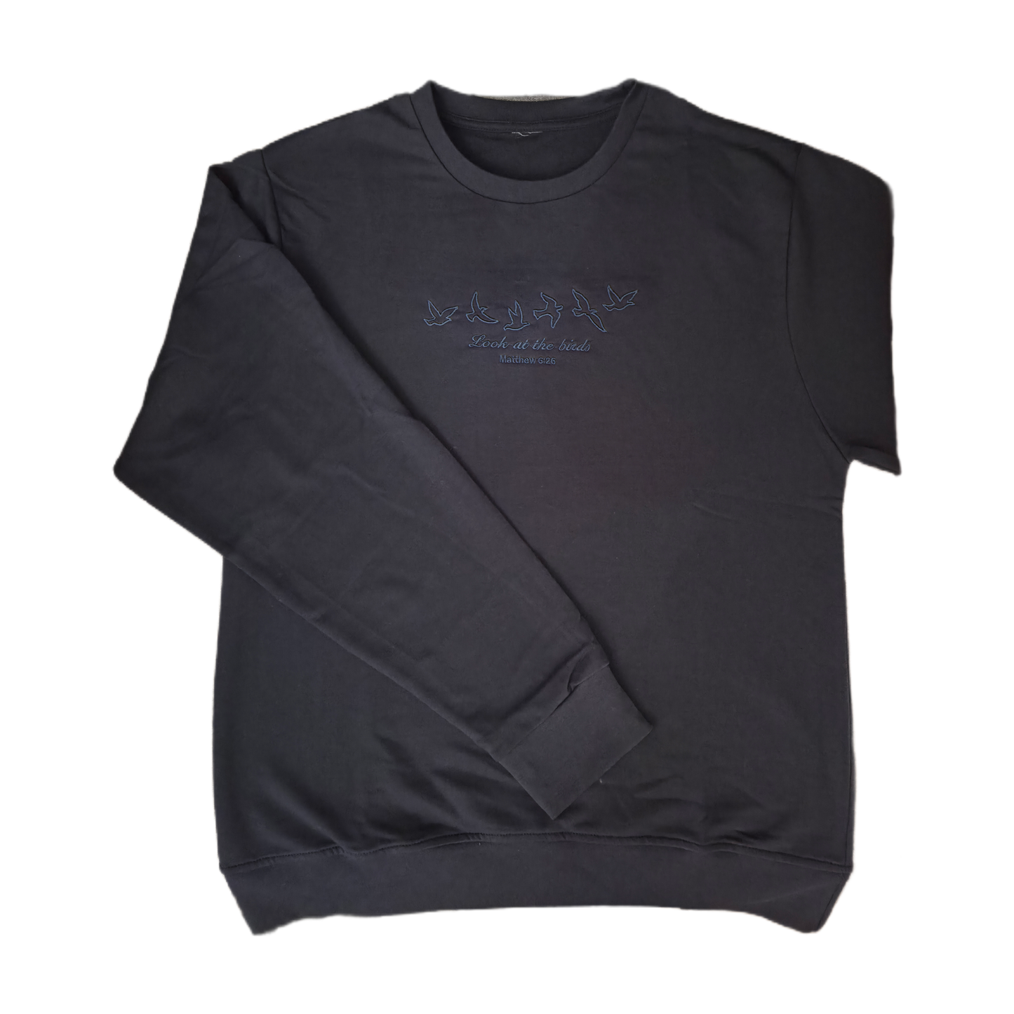 Full front view of a flat laid dark navy Christian crewneck sweatshirt with a subtle dark blue embroidered design of flying birds and the Bible verse Matthew 6:26.