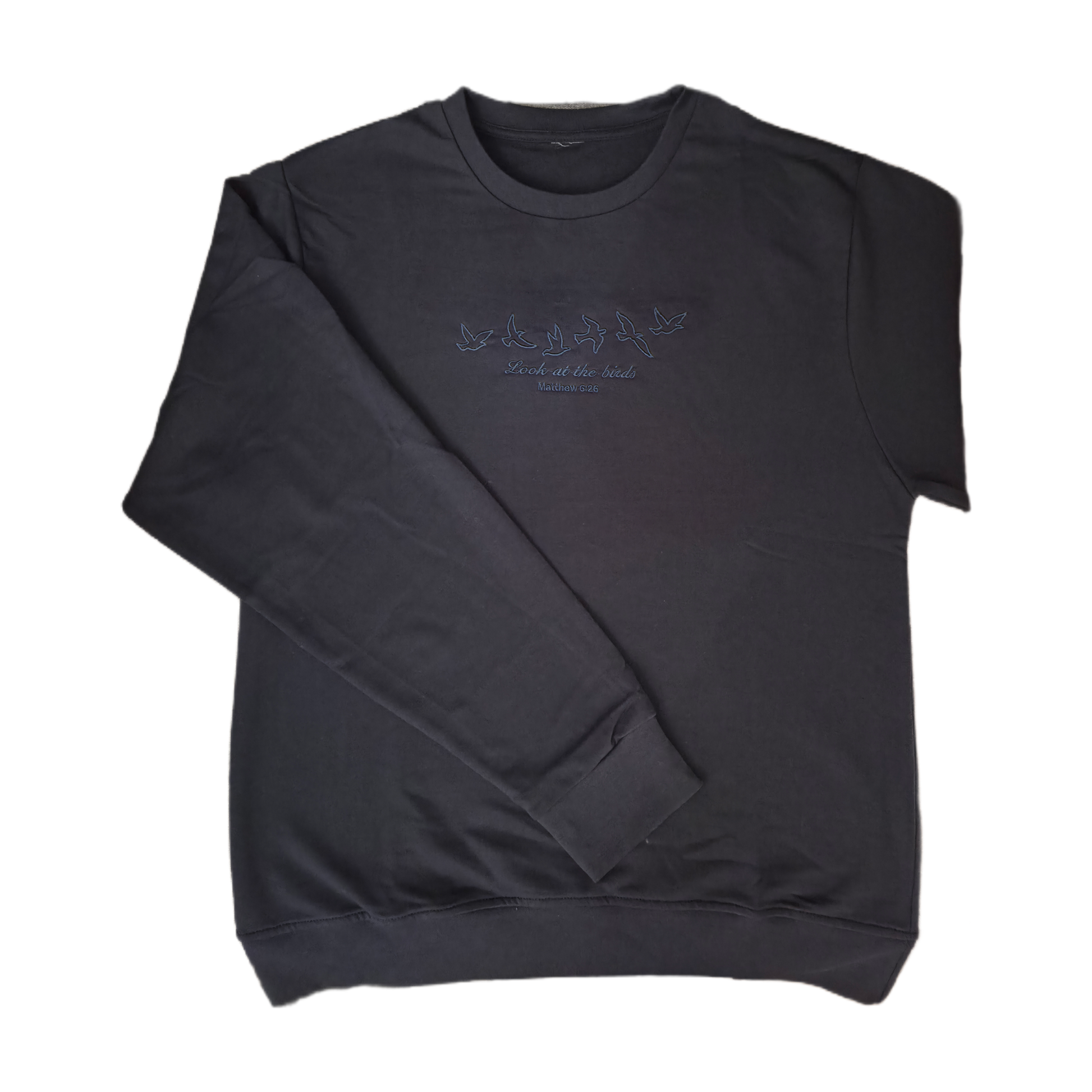 Full front view of a flat laid dark navy Christian crewneck sweatshirt with a subtle dark blue embroidered design of flying birds and the Bible verse Matthew 6:26.